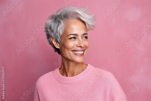 Portrait of a happy senior woman with grey hair and pink sweater