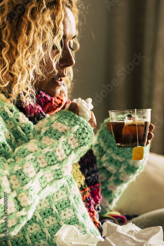 Coronavirus. SIck woman with cold flu influenza alone at home driniking herbal tea or medicine to fight the contagion - coronavirus lockdown covid-19 people - healthy emergency worldwide photo