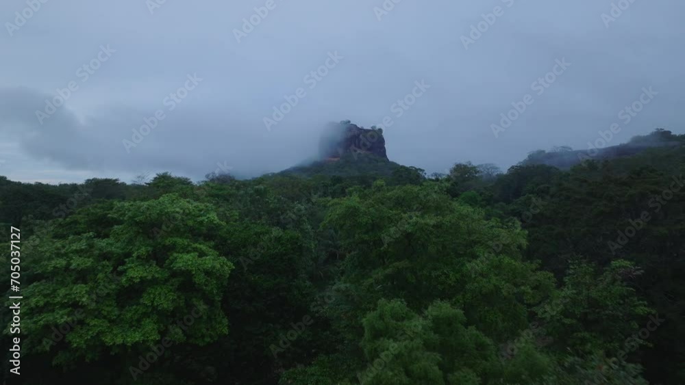 Forwards fly above tropical rainforest. Rocky protrusion shrouded in low clouds. Sigiriya, Sri Lanka Forwards fly above tropical rainforest. Rocky protrusion shrouded in low clouds. Sigiriya, Sri Lanka