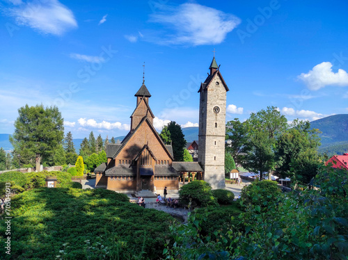 Old wooden Vang stave church with stone tower in summer. Karkonosze mountains, Karpacz, Poland photo