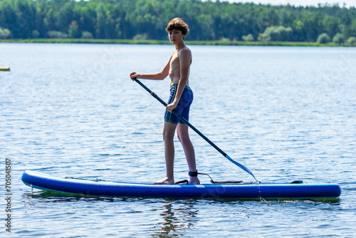 Teenager and SUP board. Active recreation on the Senftenberg lake. Federal land of Brandenburg. Germany. © Sergey Kohl
