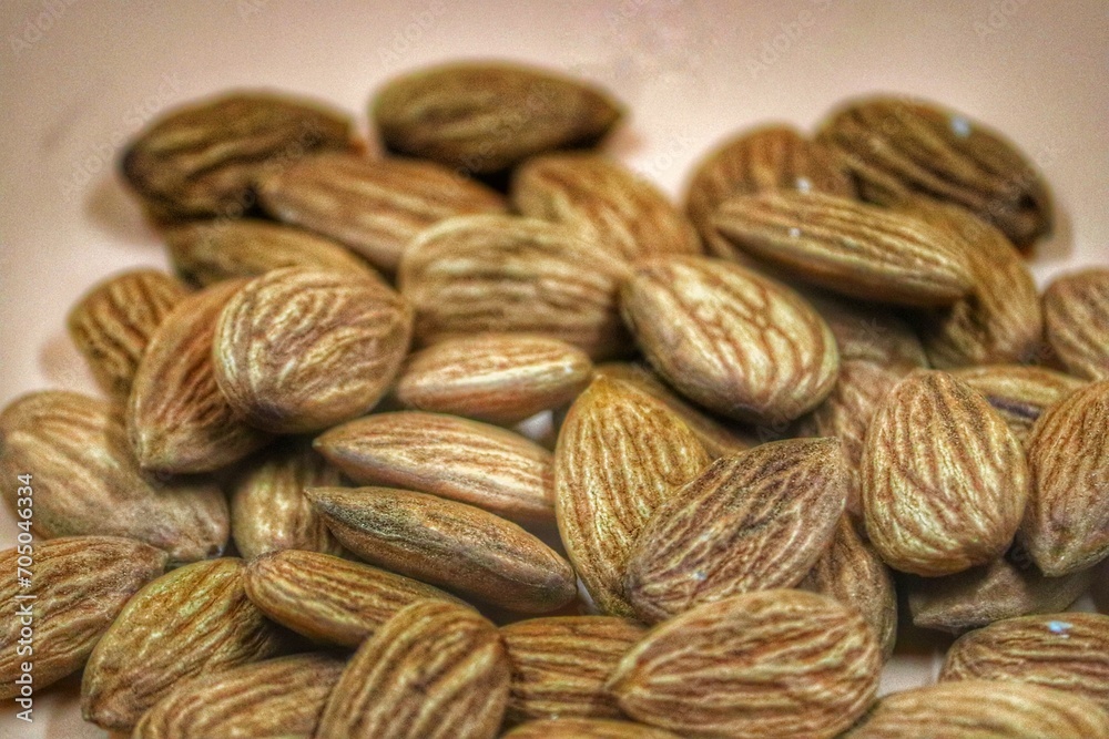 Fototapeta premium Closeup of a pile of almonds on a beige background.
