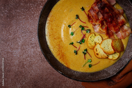 Pumpkin cream soup, curry, fried bacon, bruschetta chips,micro-greens, top view, no people,