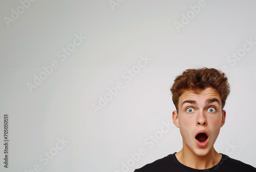 Astonished Young Man with Eyes Wide Open on a Light Background
