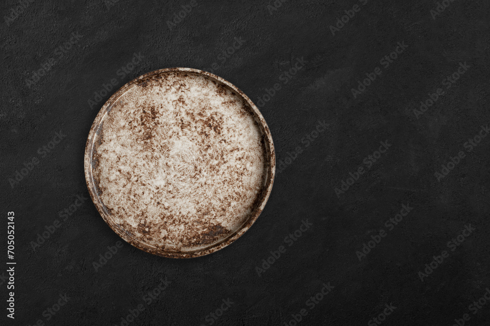 Handmade empty ceramic plate top view with copy space on dark concrete table. Minimalism. Eco friendly ceramics handcraft tableware. Handmade empty ceramic plate top view with copy space on dark concrete table. Minimalism. Eco friendly ceramics handcraft tableware.