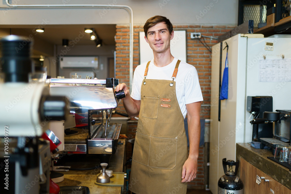 Professional young coffee barista standing inside the counter bar in the coffee shop and making arms crossed and looking at camera, handsome - good looking caucasian ethnic barista posing. Professional young coffee barista standing inside the counter bar in the coffee shop and making arms crossed and looking at camera, handsome - good looking caucasian ethnic barista posing.