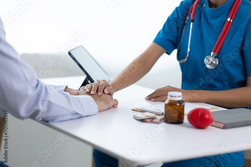 Male patient discussing with female doctor in examination room at hospital. Consultation of health care from a doctor who specializes in medicine from the hospital.