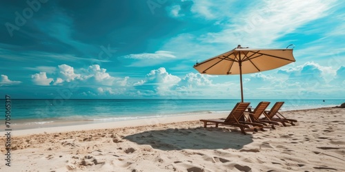 Lounge chairs and an umbrella set up on a beautiful beach. Perfect for relaxing and enjoying the sun.