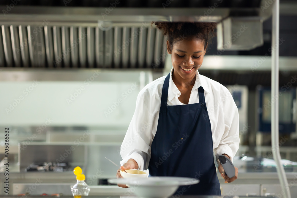 Happy African American woman standing with arms crossed while working as chef in a restaurant. Cooking class. culinary classroom. happy young african woman students cooking in cooking school. - obrazy, fototapety, plakaty 