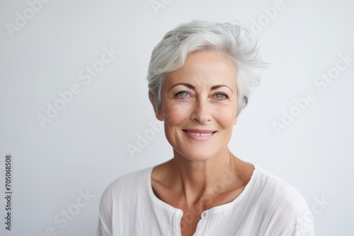 Portrait of a smiling senior woman looking at camera isolated on a white background