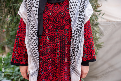 Portrait for woman wearing traditional clothes in refugee camp behinde olive tree