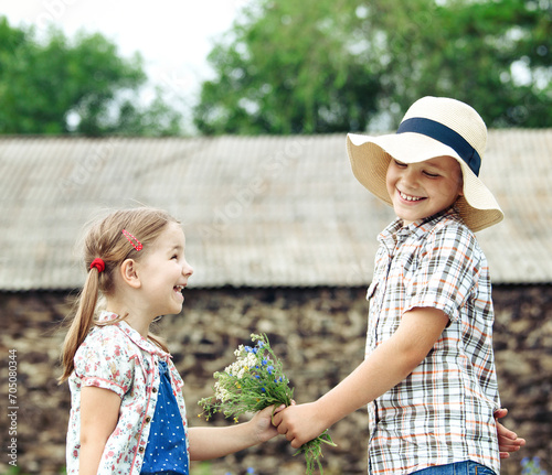 Little boy gives flowers to the little girl