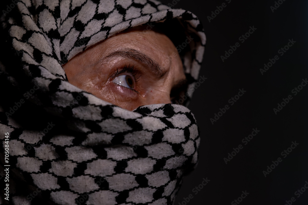 portrait of pearson wearing white keffiyeh on dark background with anger expression on his eyes due to violence and against occupation