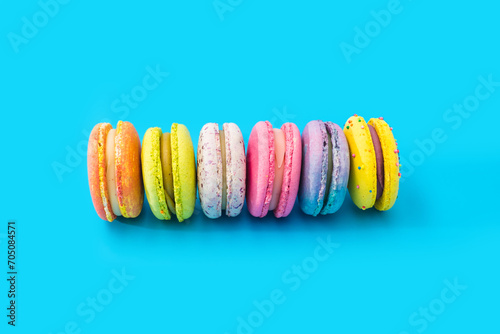 Brightly colored stacked macarons on blue background.