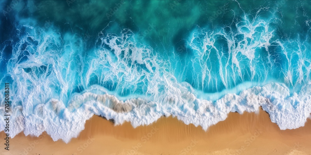 Aerial view of ocean waves crashing onto a sandy shore.