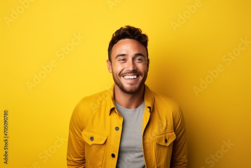Portrait of a happy young man looking at camera over yellow background
