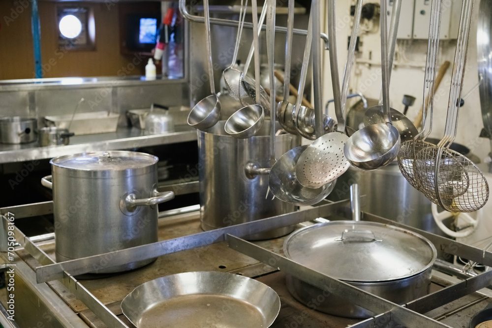 Steel saucepans and casseroles, in an industrial kitchen. Steel saucepans and casseroles, in an industrial kitchen.