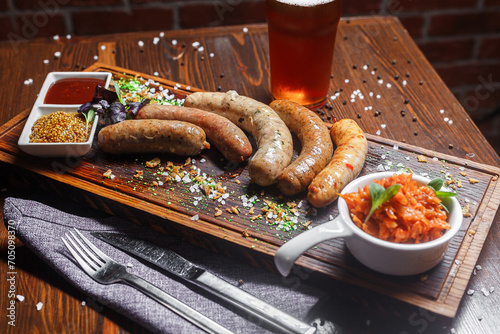 Small German boiled sausages, Nuremberg fried, on a plate, sauces and beer, dark and moody, top new