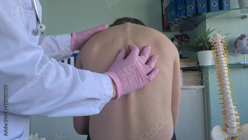 Chiropractor examining child with back pain in clinic. Spinal problem scoliosis and stoop in children photo