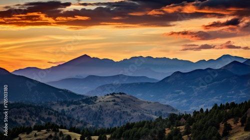 Rocky mountain range glowing under the warm tones of a sunset © Cloudyew
