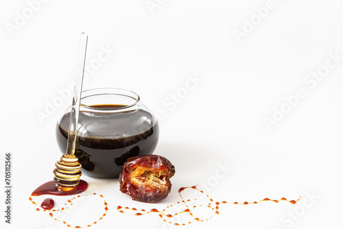 Natural date syrup in a bowl with whole dates in the background	