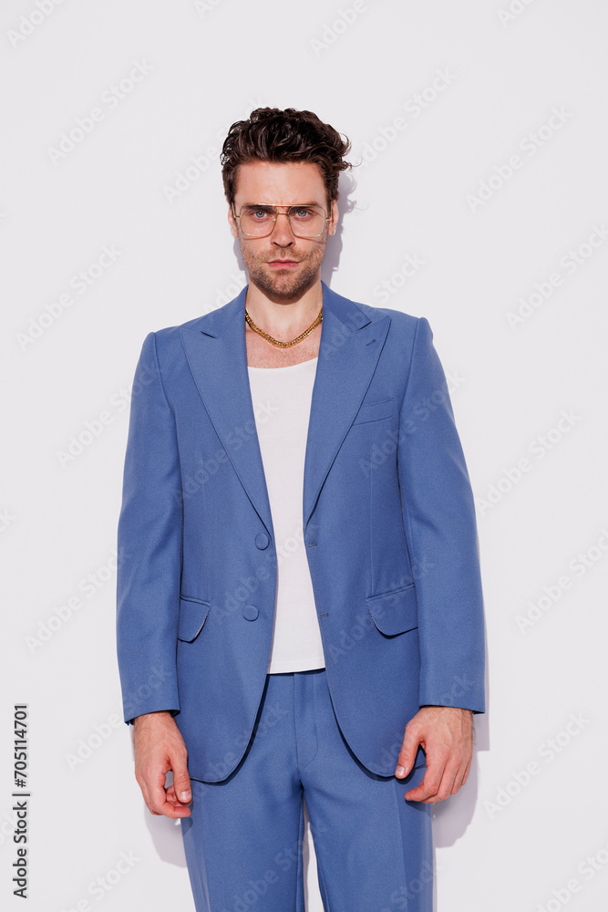 Fototapeta premium Stylish model in eyeglasses and vintage suit looking at camera in studio