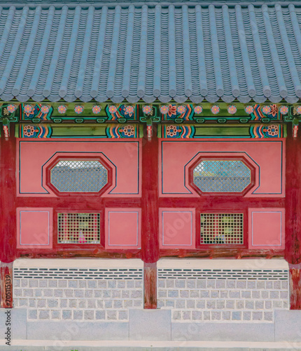 Front view of tile roof and Dancheong on the wall of Gyeongbokgung Palace, Seoul, South Korea. Close-up shot of the details of the Korean traditional Palace walls. Beautiful korean style wallpaper.