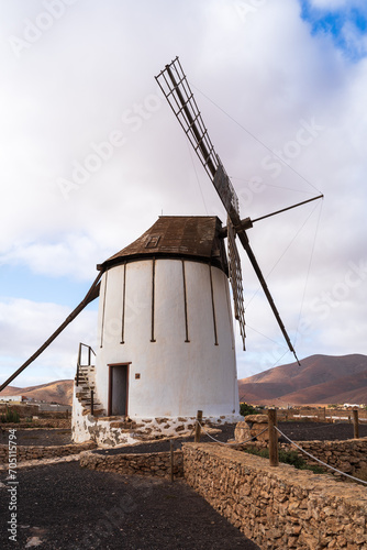 Traditional Windmill Against Mountainous Landscape: A Study in Architecture and Nature photo