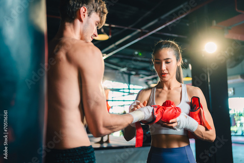 Active  athletes and fit men kick boxing and doing sport training workout in a gym. Two male partners or MMA boxer and trainer practice sparring exercises for a healthy wellness lifestyle.