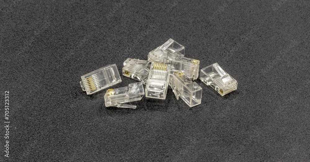 RJ-45 connectors on a sleek black backdrop. The modular design of the RJ-45 connectors is designed for twisted pair cables for Ethernet networks RJ-45 connectors on a sleek black backdrop. The modular design of the RJ-45 connectors is designed for twisted pair cables for Ethernet networks