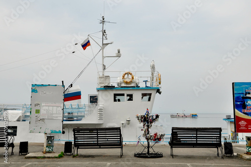 Jezioro Bajkał, Rosja. Brzeg jeziora z kamienistą plażą, tory kolejowe, łodzie, pomosty w wodzie. photo