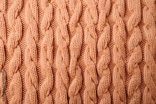 A close up of a peach fuzz knitted sweater with a large braid suitable for winter fashion websites, knitting blogs, cozy apparel advertisements, and seasonal social media posts.