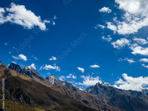 Cold climate landscape of the snow capped mountains with cloudy blue sky