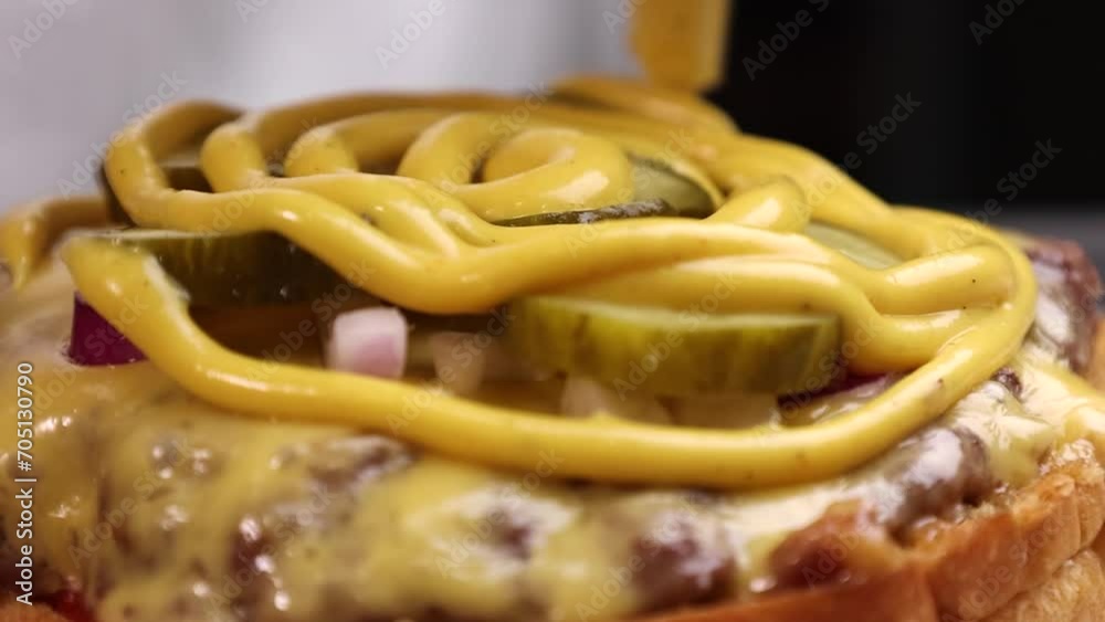 burger with cutlet cheese and onions and pickled cucumbers is poured with sauce burger with cutlet cheese and onions and pickled cucumbers is poured with sauce