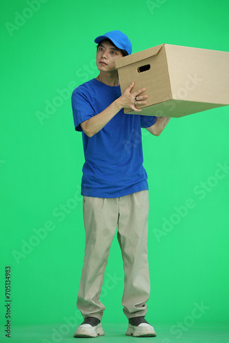 The delivery guy, on a green background, in full height, shakes the box