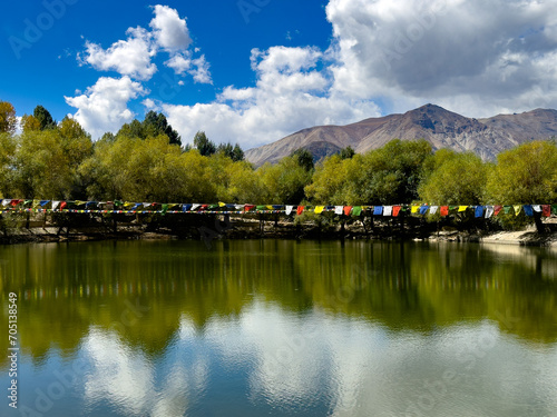 reflection of clouds and trees in a lake in the himalayan mountains. Taken at Nako lake, spiti valley, himachal pradesh