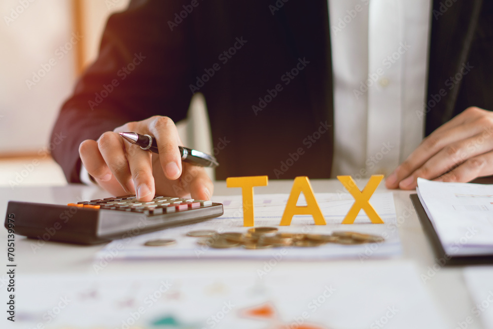 Tax Gold wooden text , Pay tax in 2024 years, Man Using calculator to calculate Individual Income and the new year 2024 Filling out writing taxes online tax concept. - obrazy, fototapety, plakaty 