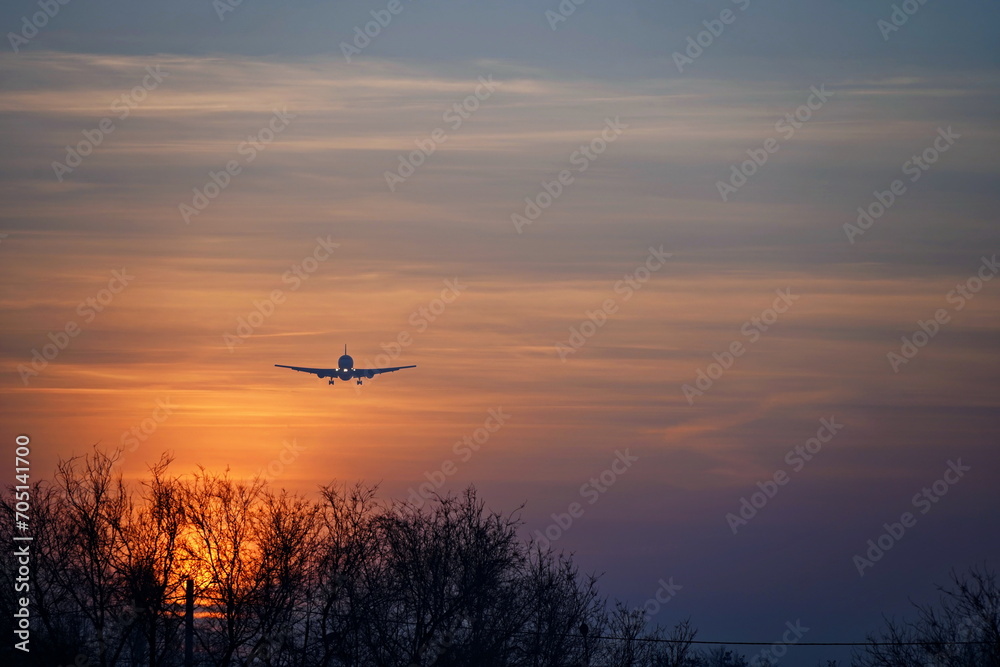 The plane flies in the sky during sunset. The plane flies in the sky during sunset.