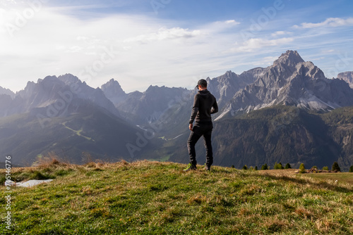 Hiker man with scenic view of majestic mountain peaks of untamed Sexten Dolomites in South Tyrol, Italy, Europe. Hiking on Monte Elmo in autumn. Wanderlust concept in Italian Alps. Tranquil atmosphere