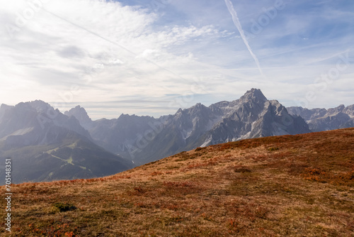 Alpine meadow in golden autumn with panoramic view of majestic mountain range of untamed Sexten Dolomites, South Tyrol, Italy, Europe. Hiking concept Italian Alps. Looking from lift station Helmjet