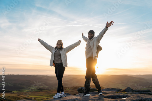 happy couple in love walking along countryside at the sunset.  Love, hiking and active lifestyle concept photo