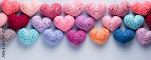 Rows of crochet hearts in pastel colors on white background, cute and creative banner or background for crafting and hobbies, or Valentines Day designs. © salarko