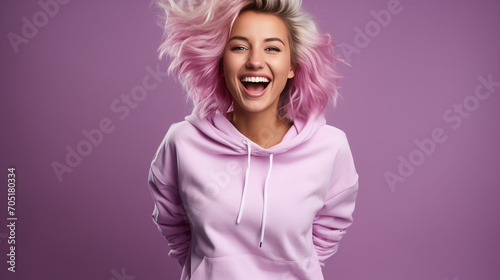 Isolated on a purple background, a happy, attractive young woman in the Gen Z style with short blond hair, a cute smile, and shoes, pants, and a pink sweater, is dancing and bouncing photo
