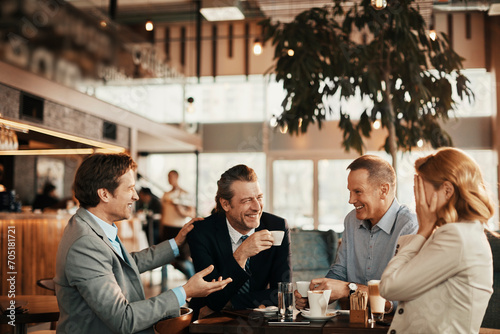 Happy diverse business people laughing in cafe photo