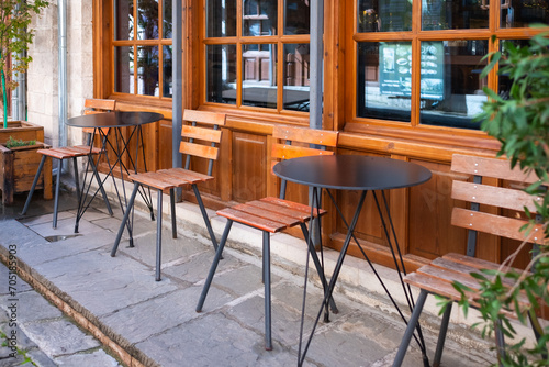 Street view of a coffee terrace with tables and chairs. Free cafe table. Outdoor empty coffee and restaurant terrace © Elena_Alex