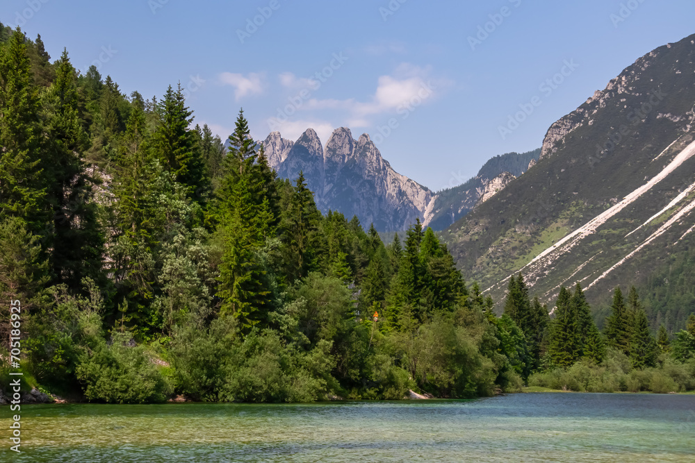 Scenery of Lake Predil with panoramic view of majestic mountain peak Cinque Punte, Tarvisio, Friuli Venezia Giulia, Italy. Tranquil scene in summer. Alpine landscape in Julian Alps, border Slovenia