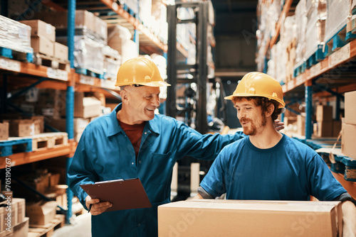 Two male warehouse workers with clipboard and package photo