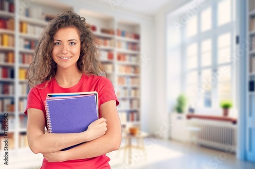 A student female holding books in a library