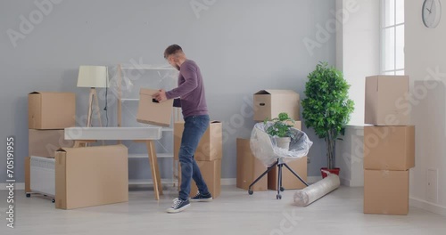 Man moving new apartment, happy cardboard dance, excited homebuyer transporting boxes dancing, organizing new home move, changing residence for better, male independence and fresh life beginning photo