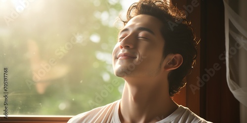 Young Asian man enjoying the sunlight photo